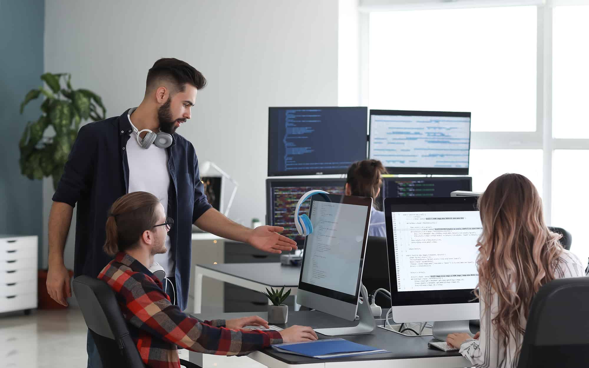 IT Support Team Member Helping Coworker with Computer Issues